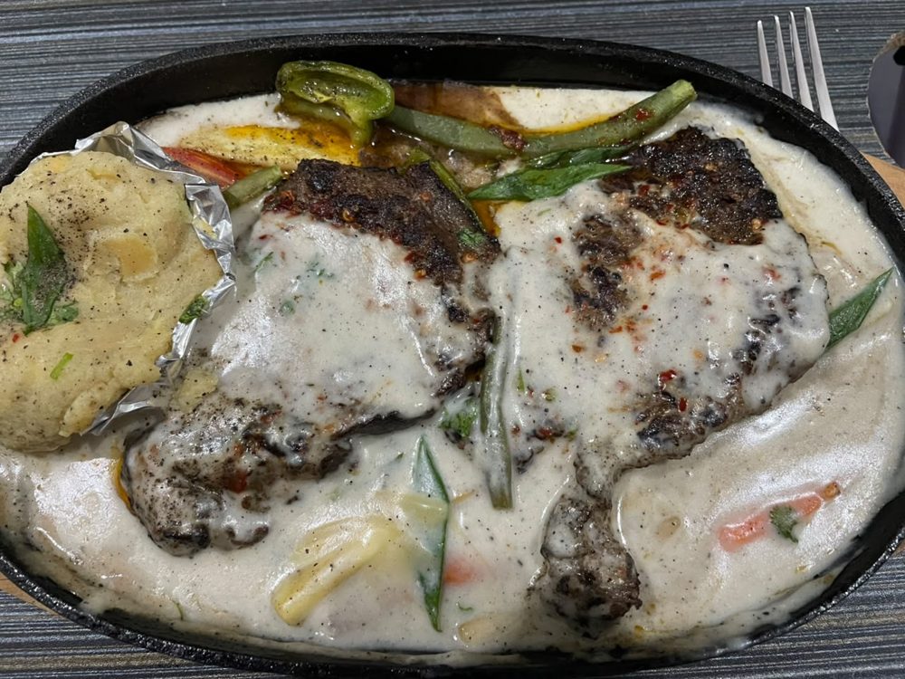 Iffat's signature creamy beef steak on a sizzling plate